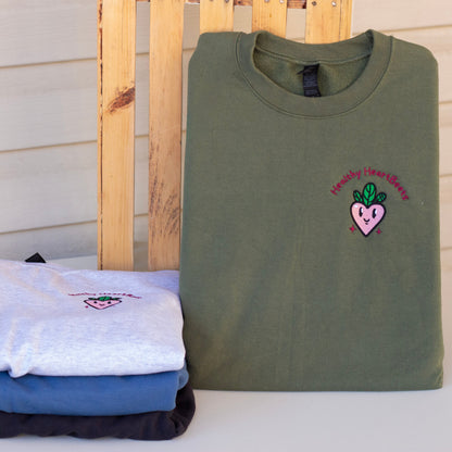 Folded shirts with embroidered designs on a wooden surface